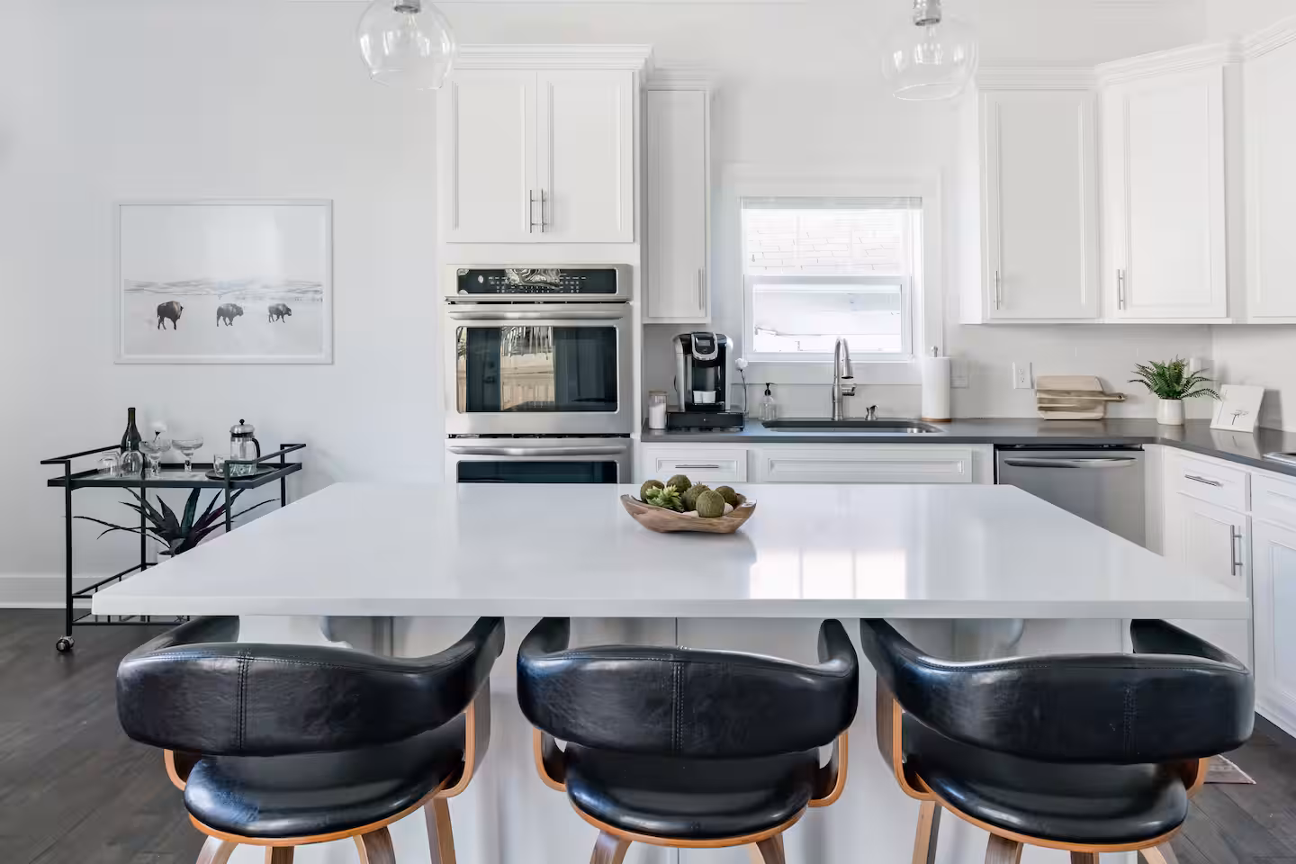 Eat-in kitchen with white cabinetry and a large island